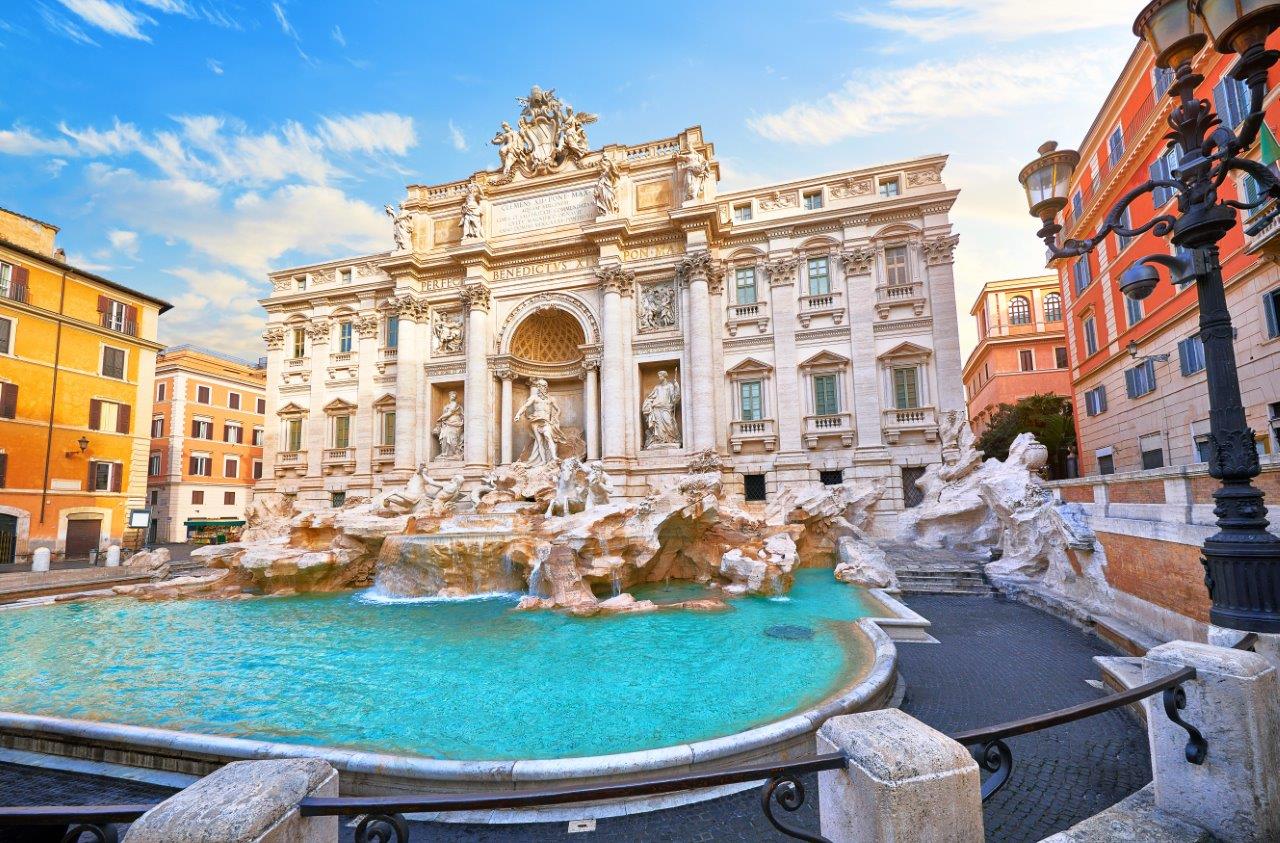 Die Fontana di Trevi ist ein prächtiger barocker Brunnen in Rom, umgeben von imposanter Architektur. Strahlend blauer Wasserfontänenfluss und eindrucksvolle Skulpturen vermitteln eine Atmosphäre von Eleganz und historischer Bedeutung. Touristen werfen Münzen in den Brunnen, um ihre Rückkehr nach Rom zu sichern.