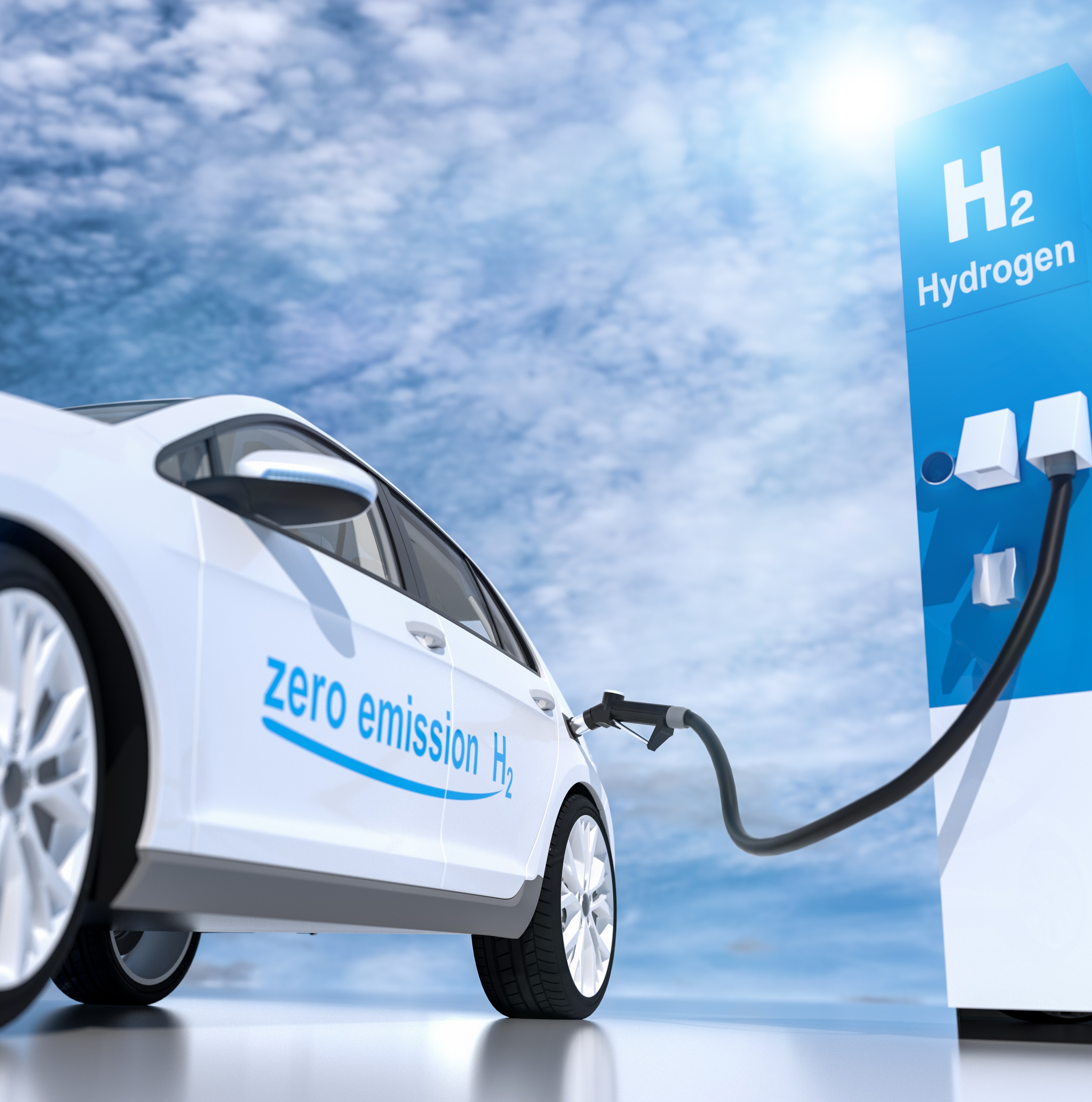 A hydrogen fuel cell vehicle is refueling at a hydrogen station. The car features a "zero emission H₂" label, emphasizing its environmentally friendly technology. The background shows a clear sky, symbolizing clean energy.